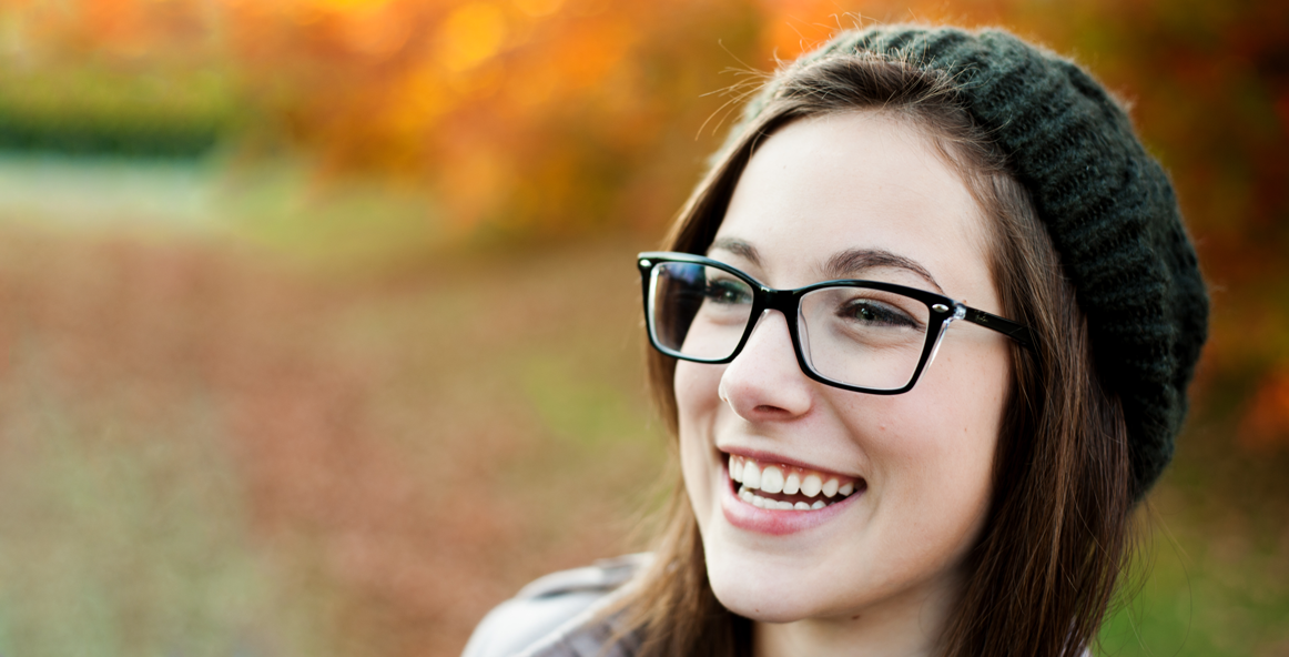 woman with knit hat and nice glasses laughing